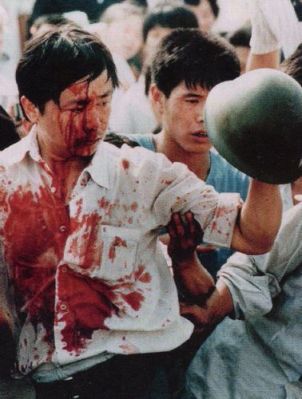 Một người biểu tình bị thương phô trương chiếc nón đã giật được. Cũng có cả 23 người lính chết trong cái đêm của bạo lực đấy. Ảnh: GEO Epoche