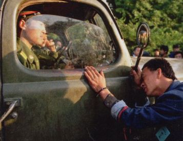 Người dân liên tục chận các đoàn xe lại. Có người khóc, có người thì van xin những người lính phần nhiều trẻ tuổi. Nhưng chính họ cũng cảm thấy căng thẳng và bị đe dọa bởi đám đông. Ảnh: GEO Epoche.