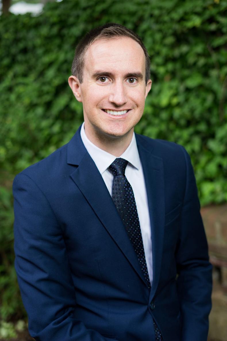 A person in a suit and tie

Description automatically generated with medium confidence